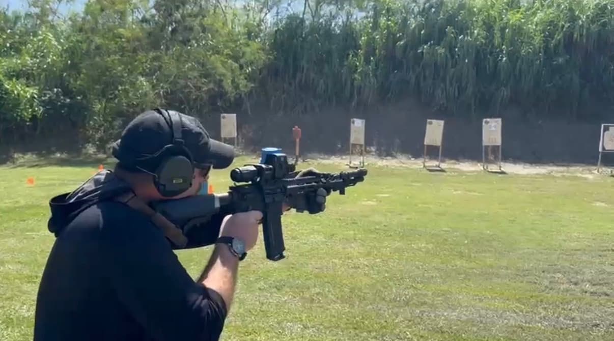 DJ training at an outdoor rifle range with targets downrange